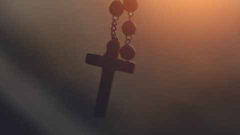 silhouette photography of hanging rosary